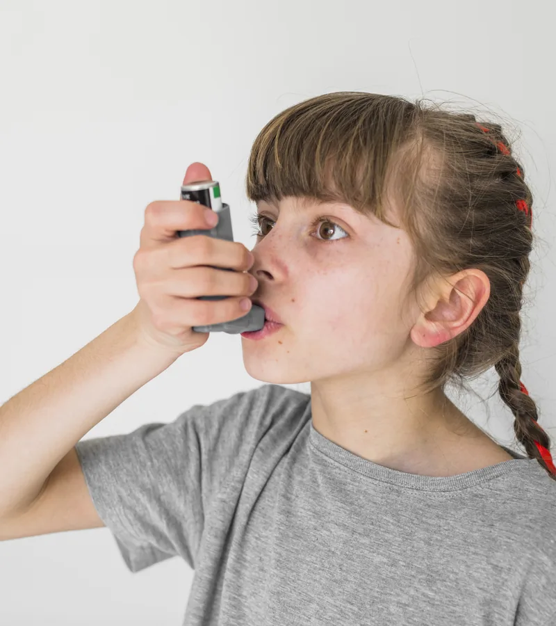 Menina usando bombinha para asma
